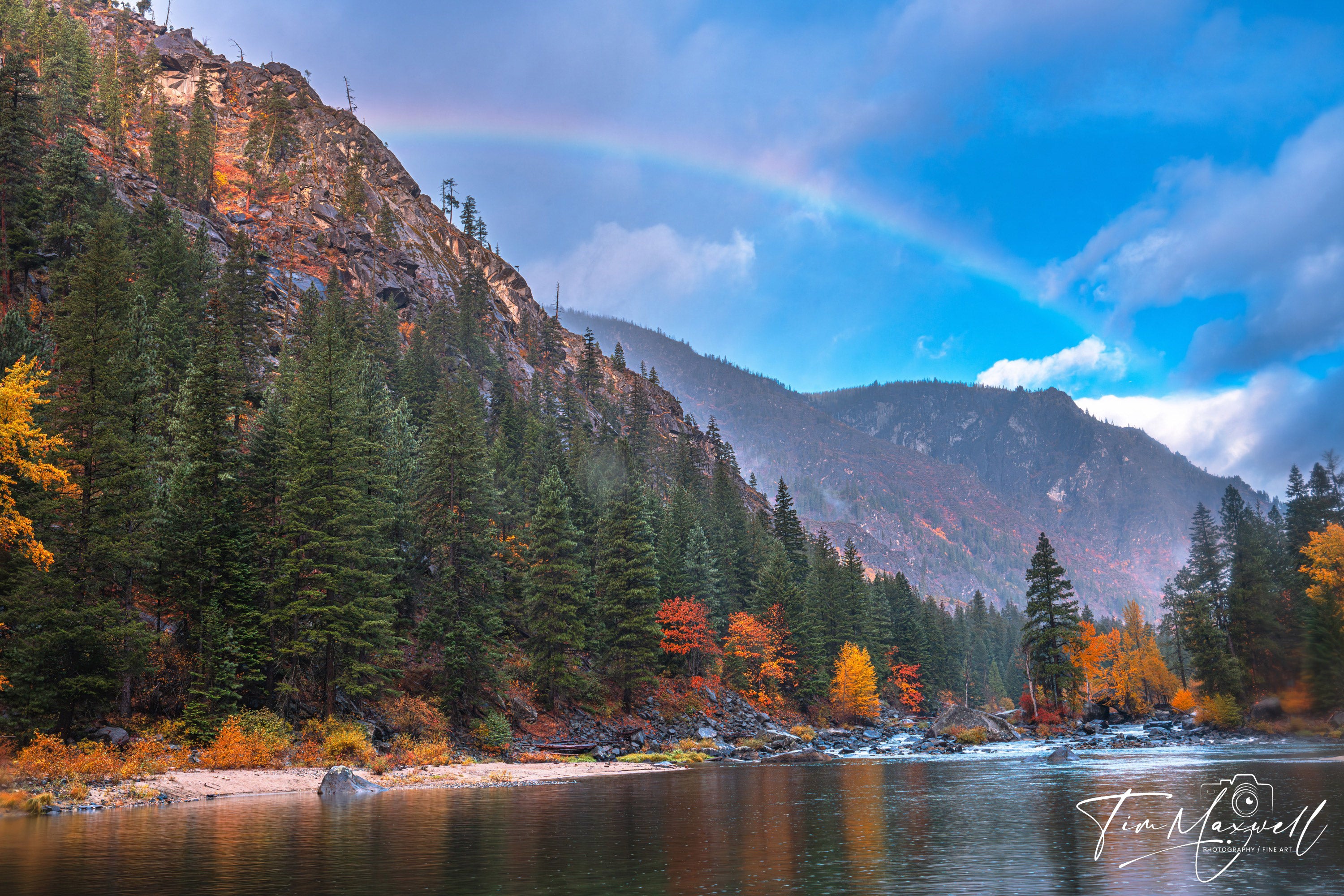 Rainbow over Tumwater Canyon cliffs with peak autumn color reflecting in the Wenatchee River; fine art print by Tim Maxwell.