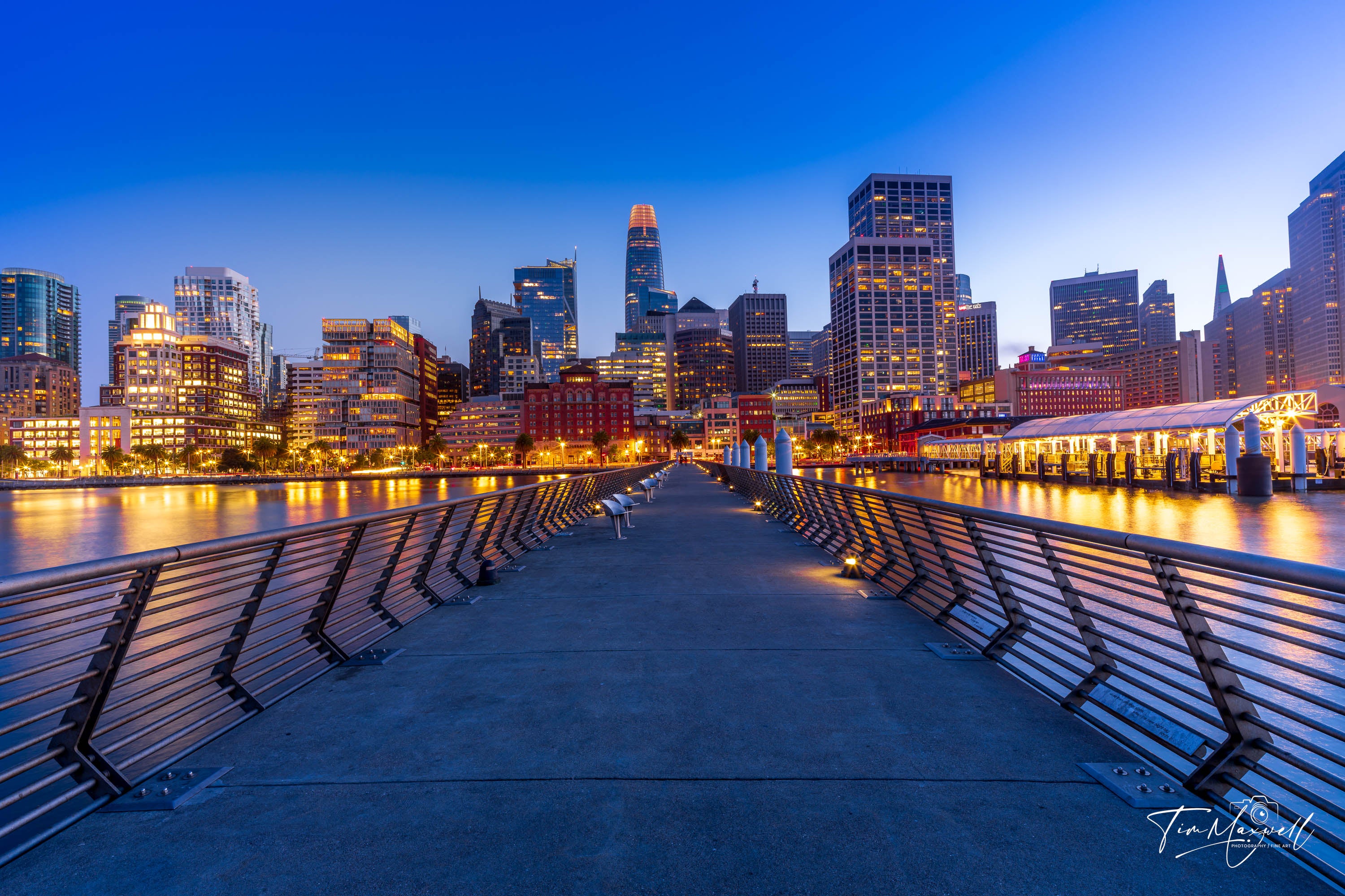 San Francisco skyline at twilight from Pier 14 with glowing city lights reflecting on the bay